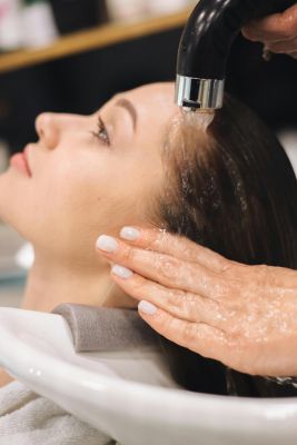 Close-up of a woman getting her hair washed at a salon, highlighting professional care.
